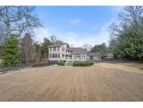 Expansive yard showcases a charming home with a patio overlooking the manicured lawn and distant trees at 3167 Bay View Dr, Jonesboro, GA 30236