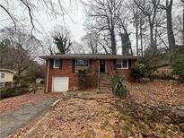 Traditional brick home featuring a front-facing garage, black shutters, and steps leading to the front door at 1900 Calloway Nw Dr, Atlanta, GA 30314