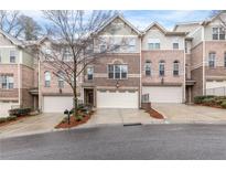 Charming brick townhome featuring an attached two-car garage and well-manicured landscaping at 2363 Palladian Manor Se Way # 4, Atlanta, GA 30339