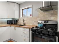 Bright kitchen featuring white cabinets, butcher block counters, and stainless steel appliances at 5558 Kingsport Dr # 27, Atlanta, GA 30342