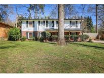 Charming two-story home with brick accents, black shutters, and a well-maintained lawn in a tree-lined neighborhood at 933 Vistavia Cir, Decatur, GA 30033