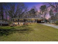 Charming brick home with a welcoming front porch and a well-maintained lawn at 441 Navarre Dr, Stone Mountain, GA 30087