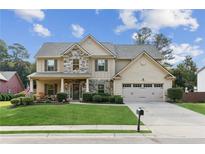 Charming two-story home featuring stone accents, manicured lawn, and a welcoming front porch at 3975 Silverthorn Trce, Cumming, GA 30028
