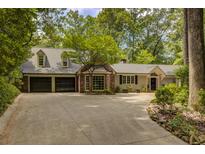 Charming home with a two-car garage, brick window feature, and a long driveway surrounded by lush greenery at 366 Blackland Nw Rd, Atlanta, GA 30342