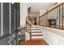 Inviting entryway featuring hardwood floors, staircase with wood and iron railings, and view into the living spaces at 2251 Limehurst Ne Dr, Atlanta, GA 30319