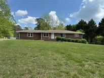 Charming brick home featuring a lush front lawn and mature trees at 3868 Demooney Rd, Atlanta, GA 30349