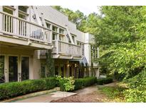 Unique home exterior showcasing a multi-level balcony and lush landscaping at 9121 Selborne Ln, Chattahoochee Hills, GA 30268