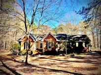 Charming brick home with front lawn, surrounded by mature trees on a sunny day at 460 Rabbit Run, Mcdonough, GA 30252