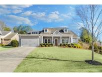 Charming single-Gathering home featuring a well-manicured lawn and an attached two-car garage at 302 Canter Way, Woodstock, GA 30188