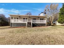 Charming ranch-style home featuring a welcoming front porch and well-maintained lawn at 255 Pine Valley Dr, Powder Springs, GA 30127