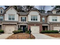 Charming townhome with brick and siding exterior, attached garages, and manicured landscaping at 5107 Madeline Pl, Stone Mountain, GA 30083