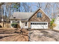 Charming home featuring stone accents, a two-car garage and well-manicured landscaping at 5532 Riverside Dr, Sugar Hill, GA 30518