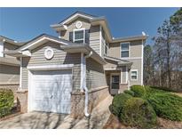 Inviting exterior of a two-story home with a one car garage and landscaped front yard under a bright blue sky at 573 Rendezvous Rd, Acworth, GA 30102