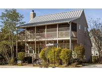 Charming two-story home with a screened-in porch on each level and lush landscaping at 10528 Serenbe Ln, Chattahoochee Hills, GA 30268