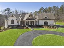Beautiful home with circular driveway, manicured lawn, and stone and white plank exterior at 5222 N Helton Rd, Winston, GA 30187