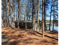 Cozy waterfront cabin nestled among trees with serene lake views and private dock access at 5400 Kings Camp Rd Se B-34, Acworth, GA 30102