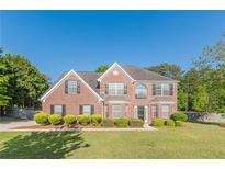 Charming two-story brick home with manicured lawn and mature landscaping at 104 Sunflower Meadows Dr, Mcdonough, GA 30252