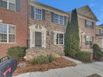 Charming brick townhome with well-maintained landscaping and welcoming front entrance at 1869 Appaloosa Mill Ct, Buford, GA 30519