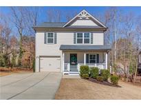 Charming two-story home with a welcoming front porch, well-maintained lawn, and a one-car garage at 6162 Hutchins Dr, Buford, GA 30518