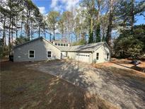 Charming single-story home with a well-maintained yard, a two car garage and a gravel driveway at 3825 Emerson St, Marietta, GA 30062