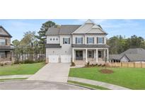 Charming two-story home with a well-manicured lawn, a two-car garage and a welcoming front porch at 5424 Gallagher Ct, Powder Springs, GA 30127