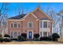 Charming two-story brick home featuring a blue front door and well-manicured landscaping at 3699 Fowler Rdg, Douglasville, GA 30135