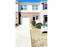 Two-story townhouse featuring a brick facade, attached garage, and neatly landscaped front yard with a for-sale sign at 6408 Kennonbriar Ct, Lithonia, GA 30058