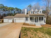 Charming home featuring a welcoming porch, dormer windows, attached garage, and a separate garage at 10067 Freeman Ct, Jonesboro, GA 30236