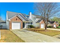 Charming two-story home featuring a brick facade, single-car garage, and well-maintained lawn under a clear blue sky at 4105 Ravenwood Ct # 3, Union City, GA 30291