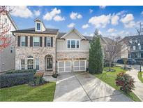 Charming two-story home featuring a brick and gray facade, manicured lawn, and a two-car garage at 667 Creswell Park, Smyrna, GA 30082