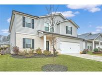 Charming two-story home with gray siding, brick accents, well-maintained lawn, and an attached two-car garage at 4929 Dufour Dr, Lilburn, GA 30047