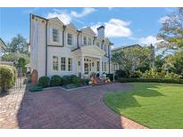 Elegant two-story home with a brick driveway, manicured landscaping, and charming front porch at 115 17Th Ne St, Atlanta, GA 30309