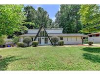 A-frame home featuring a well-manicured lawn and mature trees, offering privacy and curb appeal at 4253 Smithsonia Dr, Tucker, GA 30084