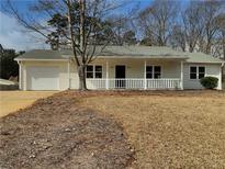 Charming single-story home with a covered front porch, attached garage, and well-maintained landscaping at 51 Lost Meadows Dr, Dallas, GA 30157