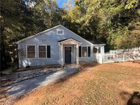 Charming light blue one-story home with a neatly maintained yard and welcoming front entrance and a picket fence at 3155 Oakcliff Nw Rd, Atlanta, GA 30311