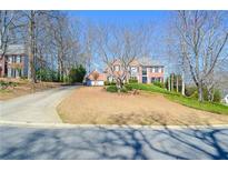 Charming two-story brick home with a well-manicured front yard and a circular driveway at 6450 Oak Valley Dr, Cumming, GA 30040