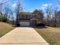 Charming two-story home with brick facade and a spacious front yard and extended driveway at 1181 Paramount Dr, Mcdonough, GA 30253