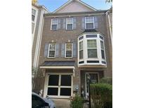 Charming brick townhouse featuring a covered entryway, bay window and a one car garage at 239 Valley Xing, Canton, GA 30114