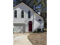 Charming home featuring a two-car garage, red front door and well-maintained lawn at 2068 Bedford Ct, Lithonia, GA 30058