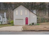 Charming two-story home with white siding, attached garage, and a beautifully colored front door at 2068 Bedford Ct, Lithonia, GA 30058