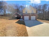 Charming brick home featuring a two-car garage and well-manicured lawn at 2363 Deer Springs Dr, Ellenwood, GA 30294