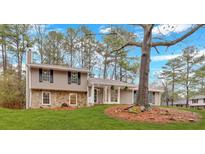 Charming split-level home with stone accents, well-manicured lawn, and mature trees for curb appeal at 3060 Eastland Way, Snellville, GA 30078