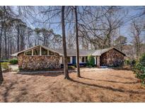 Charming stone-accented home with a modern architectural design and mature trees in the front yard at 825 Sugar Creek Se Way, Conyers, GA 30094