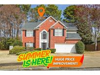 Charming two-story brick home with manicured landscaping and an attached two-car garage, perfect for families at 1390 Bridle Path Dr, Lawrenceville, GA 30045
