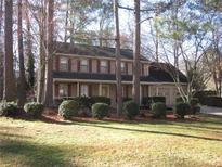 Charming two-story traditional home with a manicured lawn and mature landscaping at 9165 Eves Cir, Roswell, GA 30076