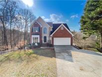 Charming brick and siding two-story home with an attached two-car garage and long driveway at 1200 Platinum Dr, Hoschton, GA 30548