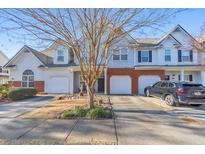 Charming townhouse with a well-manicured lawn, attached garage, and inviting curb appeal at 2415 Clock Face Ct, Lawrenceville, GA 30043