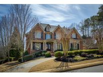 Charming two-story brick home with a manicured lawn and inviting front entrance at 3180 Wills Mill Rd, Cumming, GA 30041