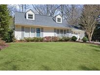 Charming home featuring dormer windows, light gray shutters, complemented by a lush green lawn and manicured landscaping at 2553 Ridgewood Nw Ter, Atlanta, GA 30318