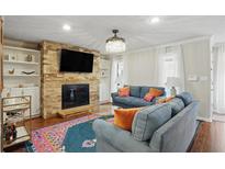 Inviting living room with a stone fireplace, built-in shelving, and cozy blue couches at 603 Dunbar Dr, Dunwoody, GA 30338